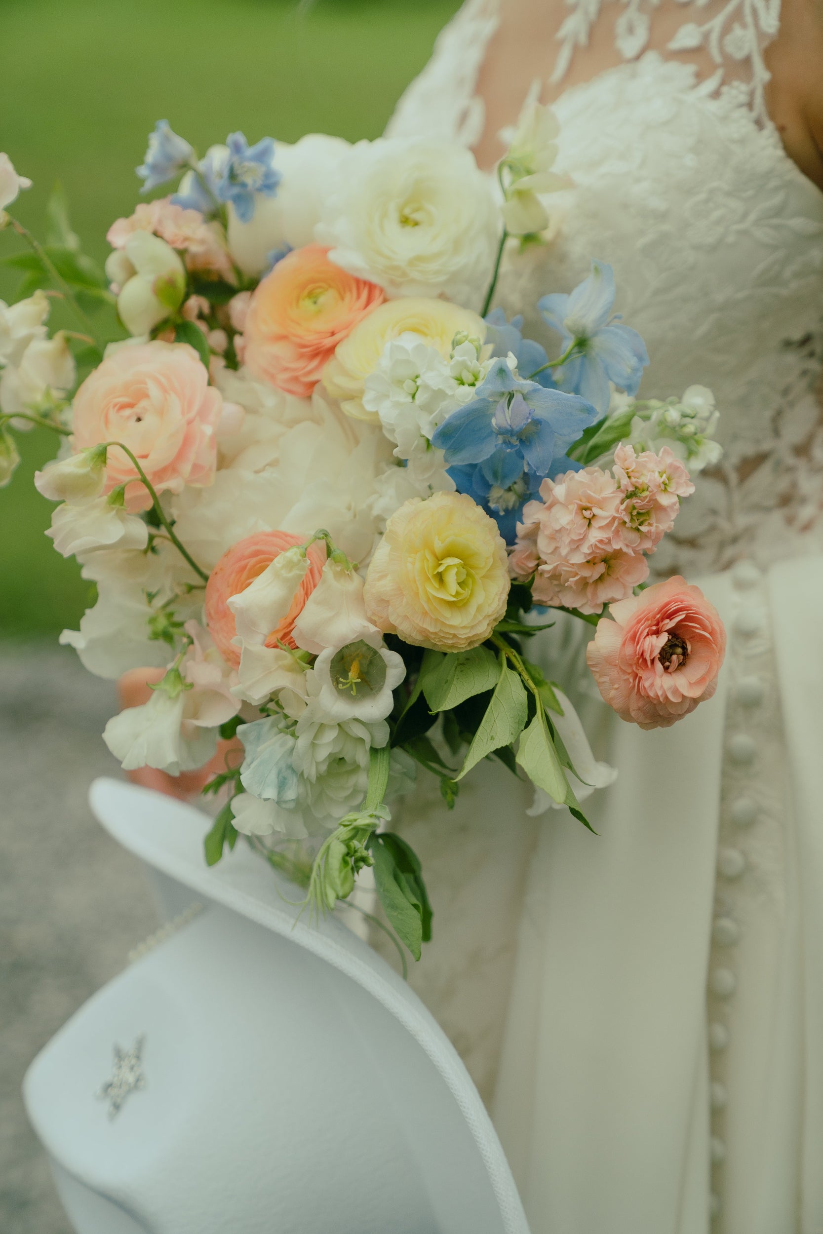 Spring wedding bouquet with ranunculus, peonies, and sweet peas